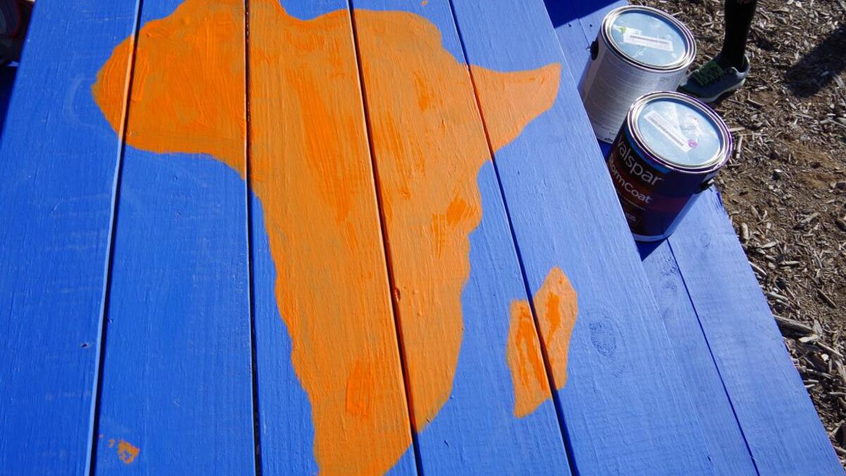Outline of africa painted on a blue picnic table